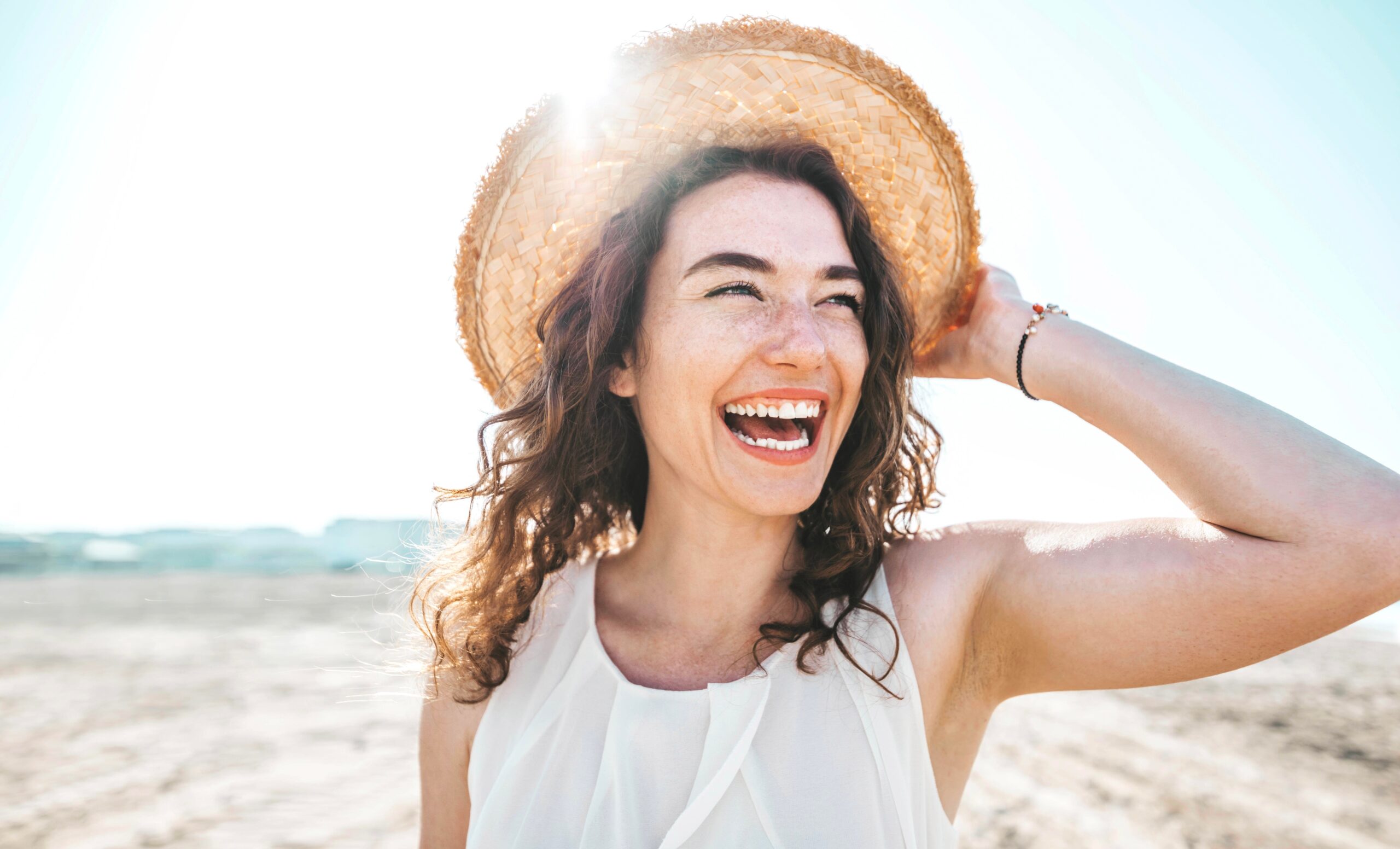 happy young woman smiling at the beach