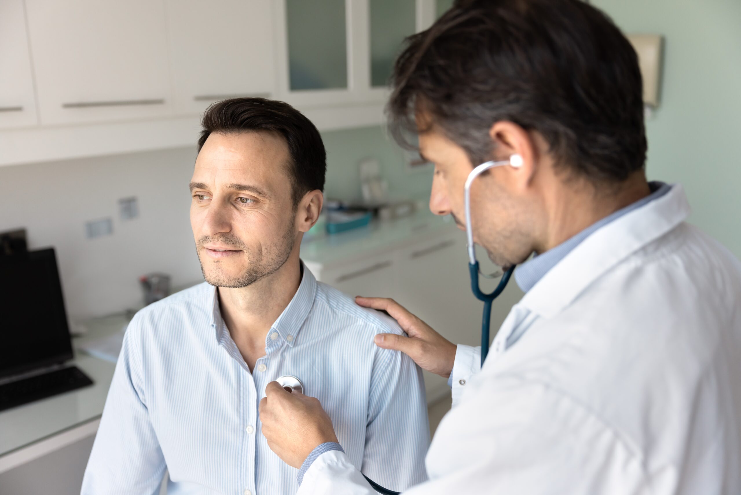 doctor examining man with stethoscope on chest