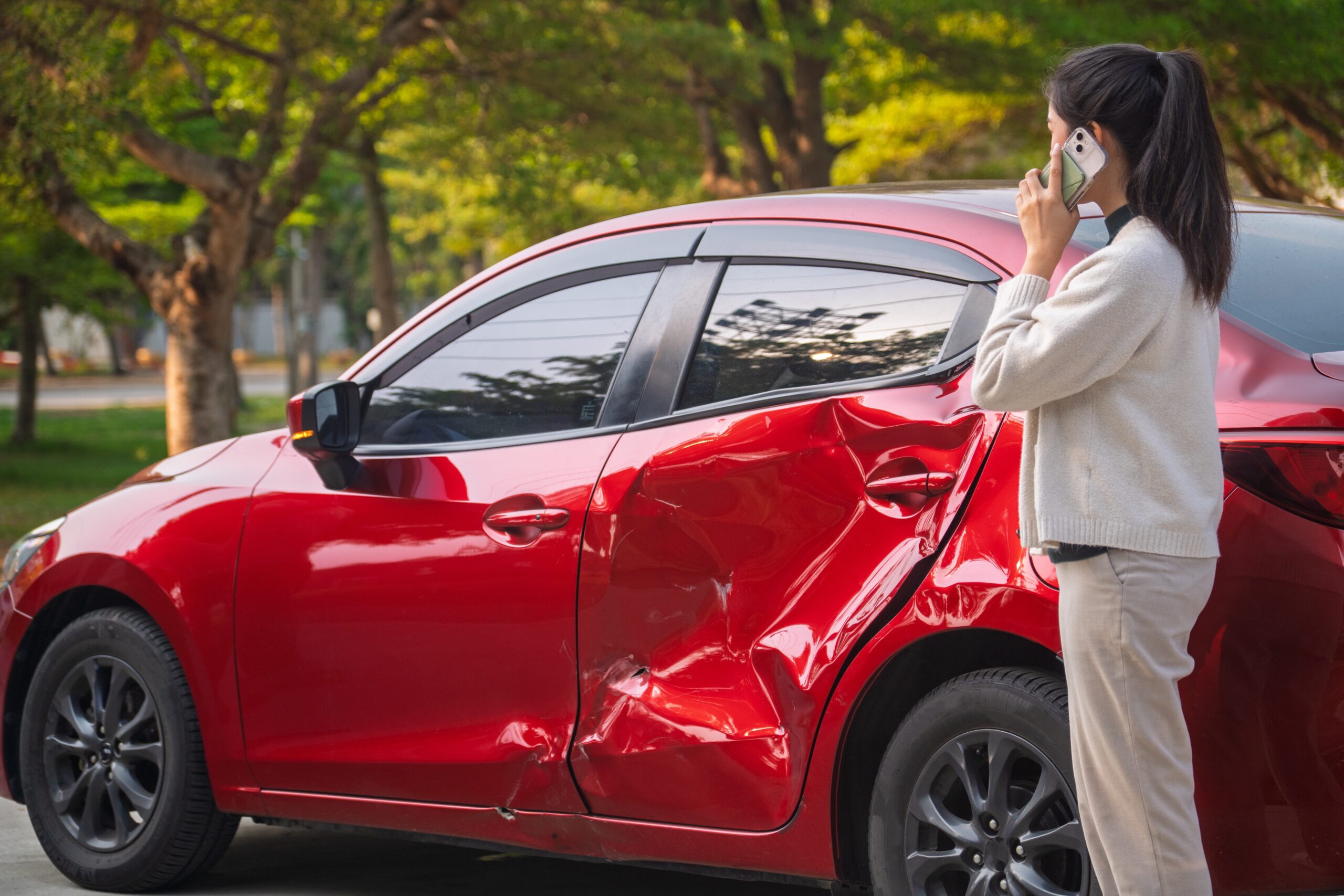 young asian woman on phone after car accident