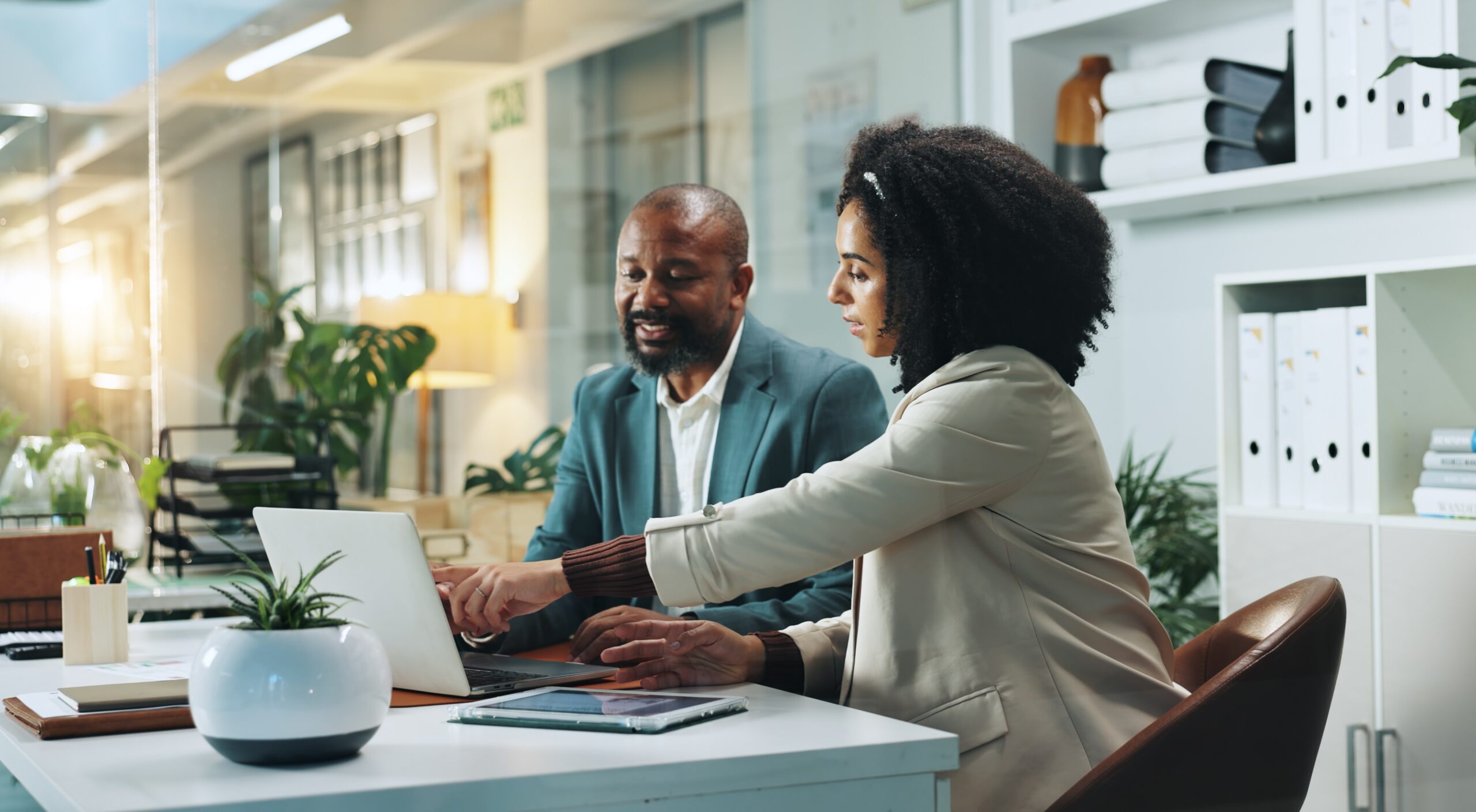 two people sitting at desk on laptop